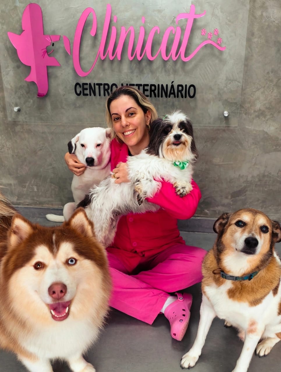 Equipe da Clinicat com quatro cães na recepção da clínica